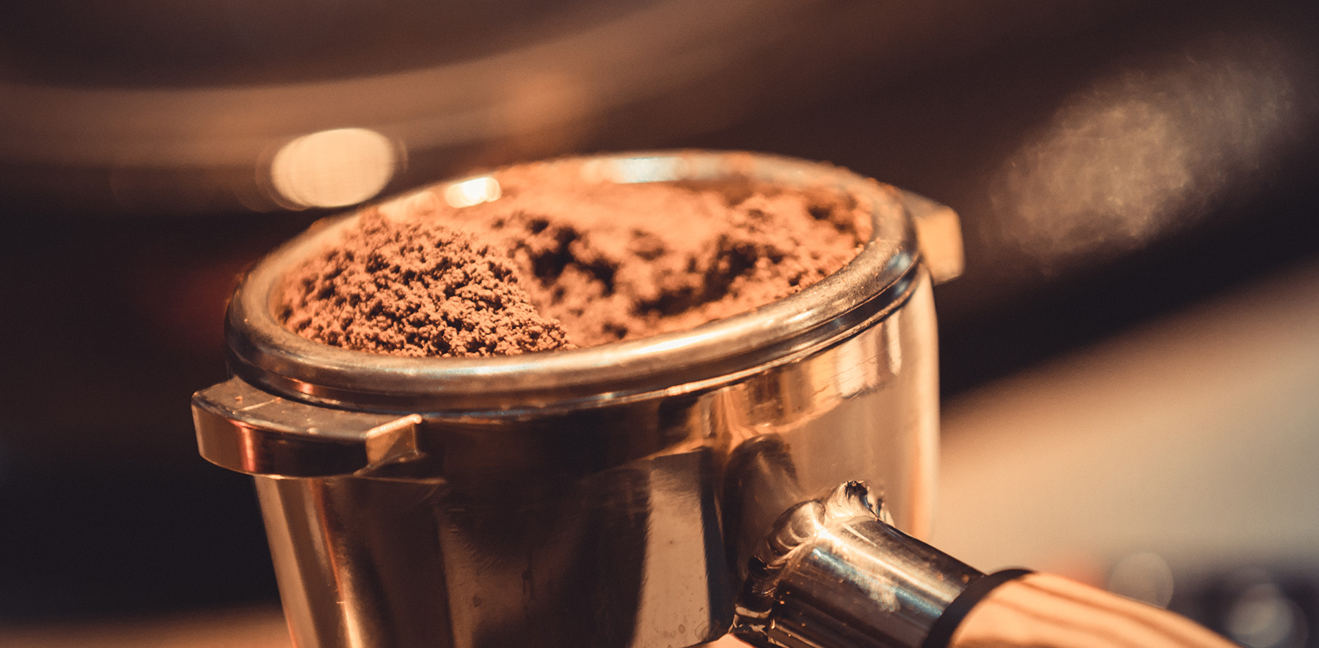 Close-up of a freshly dosed portafilter basket, ground coffee levelled at the rim.